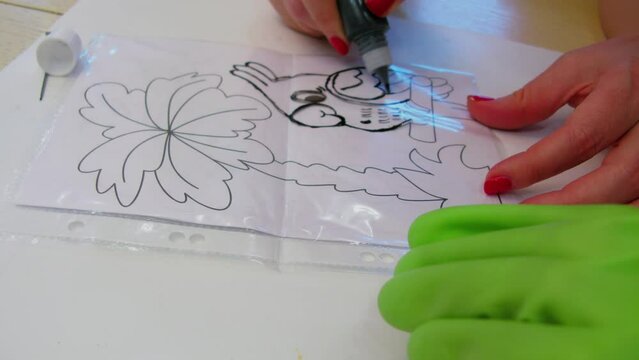 Child learns how to draw by copy of picture on transparent surface