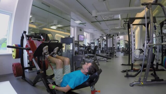 Man makes exercises on trainers in small gym. Timelapse