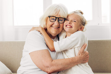 Family child hugging sofa happy home girl couch love granddaughter grandmother