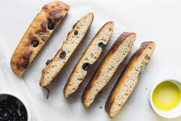 top view of olive and onion focaccia on a white background, Flatlay of focaccia with black olives and red onion topping, fresh homemade focaccia bread