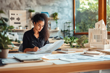 Fototapeta premium Eco-Friendly Architecture Designs. Architect working in her modern office. She makes drawings of new houses for her clients who hired her for architecture.