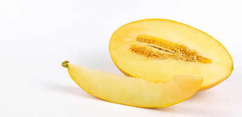 Half of a yellow melon and a slice of melon on a white background.