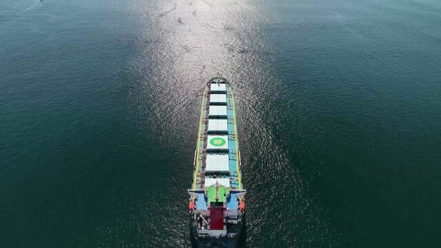 Aerial top view of cargo maritime ship with contrail in the ocean ship carrying container and running for export concept technology freight shipping by ship forwarder mast