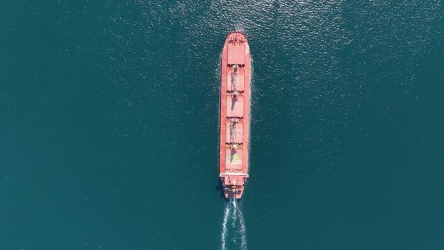 Aerial top view of cargo maritime ship with contrail in the ocean ship carrying container and running for export concept technology freight shipping by ship forwarder mast
