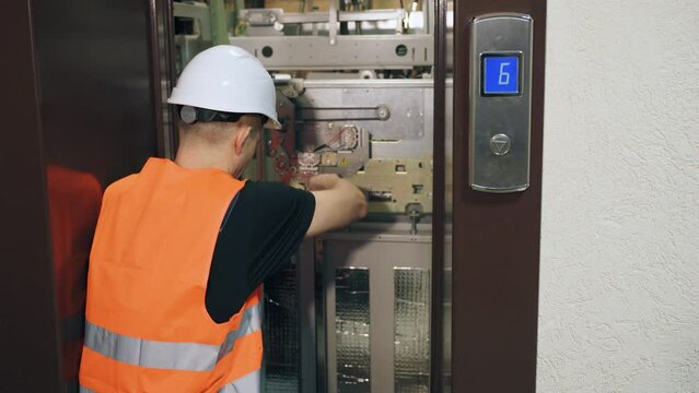 Elevator repair. A professional repairman worker sets up equipment in an elevator shaft and repairs the elevator. Elevator stop in a residential complex.