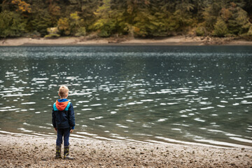 Fototapeta na wymiar child standing by the waters edge 