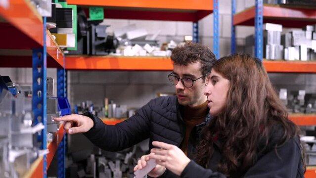 Video of two young engineers checking the stock of a cnc factory