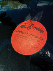 Fahrzeug mit Hinweisaufkleber in deutscher Sprache, dieses Fahrzeug steht unberechtigt auf...