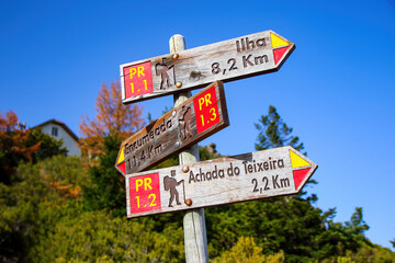Wooden orientation signs indicating the many trails surrounding the Pico Ruivo, the highest mountain peak in the center of Madeira island (Portugal) in the Atlantic Ocean