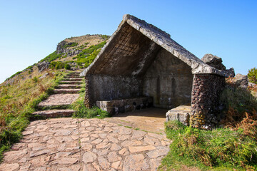 Fototapeta na wymiar Stone hideaway used as a mountain shelter on the way to the summit of the Pico Ruivo, the highest mountain peak in the center of Madeira island (Portugal) in the Atlantic Ocean