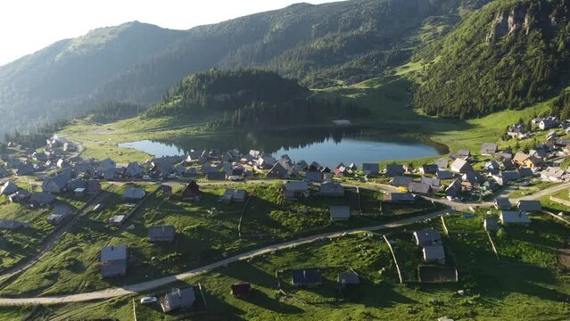 High drone view. Beautiful lake in the mountains in the morning with small wooden houses village. Prokosko lake, Bosnia and Herzegovina. 