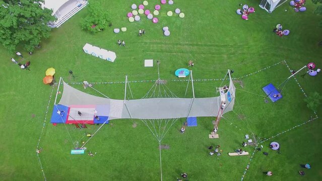 Trapeze of aerialists school with people get fun in park Luzhniki