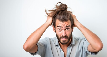Frustrated young man with long hair covering his ears. Frustrated expression