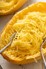 Spaghetti squash baked and pulled apart ready to eat on a baking pan