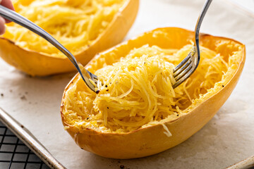 Spaghetti squash baked and pulled apart ready to eat on a baking pan