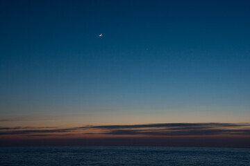 静かな海の夕暮れと三日月と金星

