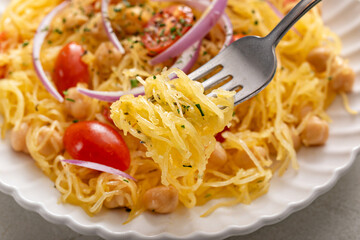 Spaghetti squash with chickpeas and tomatoes topped with red onion, low carb vegan recipe idea