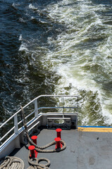 A passenger ferry watercraft boat making a big water wake and foam on Guanabara bay blue waters under a summer afternoon sunny day in Rio de Janeiro - Brazil.