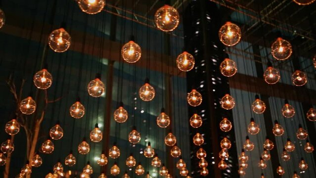Many lighting lamps hang on ropes at restaurant ceiling