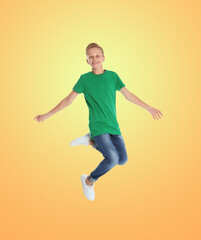 Fototapeta na wymiar Happy boy jumping on color gradient background