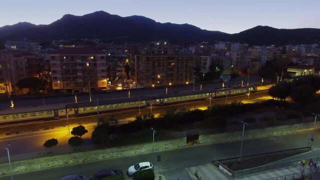 Loano, Italy, Passengers train rides near city at summer evening