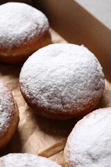 Delicious buns with powdered sugar in box, closeup