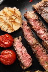 Delicious grilled beef steak with vegetables and spices on plate, top view