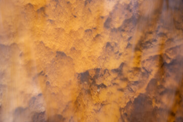 Rough Texture Of Orange Rock Through Rushing Water