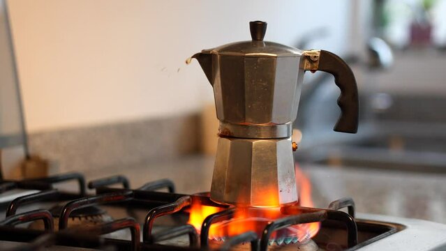 preparando cafe expreso de maquina derramando l&iacute;quido cafetera italiana sobre estufa de gas