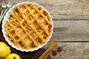 Tasty homemade quince pie served on wooden table, flat lay. Space for text