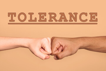 Tolerance, support and cooperation concept. People of different races making fist bump on light...