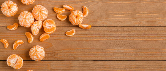 Obraz na płótnie Canvas Sweet peeled tangerines on wooden background with space for text, top view