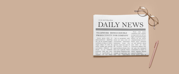 Daily newspaper with eyeglasses and pen on beige background with space for text