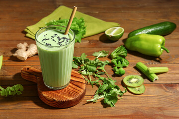 Glass of tasty juice with fresh vegetables and fruits on table