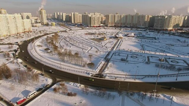 Cityscape with traffic on roundabout and park among residential houses