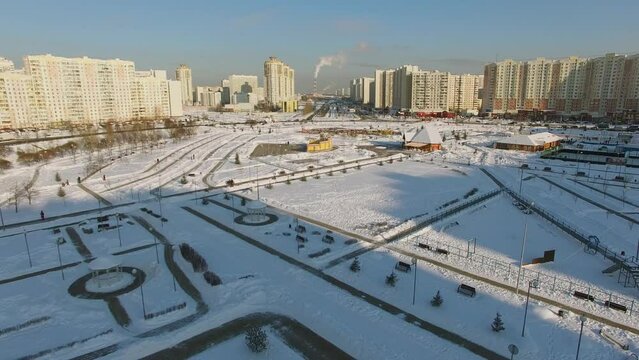 Artem Borovik park near street with traffic at sunny winter day
