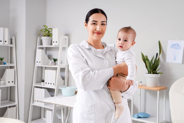 Obraz premium Female pediatrician with little baby in clinic