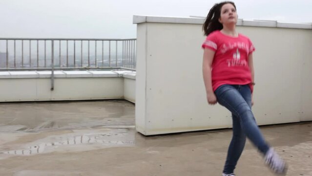 Girl dancing the national Irish dance on the roof on a cloudy day