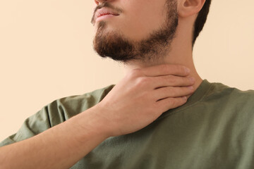 Obraz premium Young man with thyroid gland problem at home, closeup