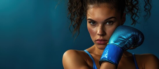 Studio portrait of a fit woman wearing blue boxing bandages. - obrazy, fototapety, plakaty