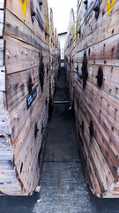 a narrow tunnel of wooden barrels with yellow and black labels