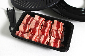 Grill pan with sliced raw beef short plate isolated on a white background