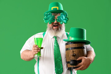 Mature man in hat with beer on green background. St. Patrick's Day celebration