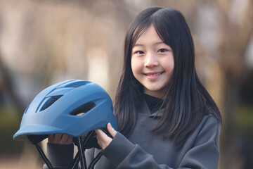 自転車用ヘルメットを持つ女の子