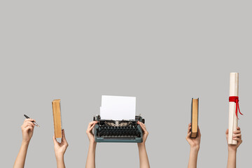 Women with vintage typewriter, diploma and books on color background