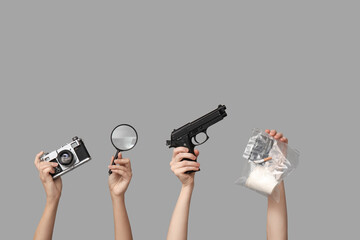 Women with accessories of detective and evidence on grey background