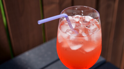 Fresh summer cocktail with strawberry juice and ice cubes. Glass of strawberry soda drink on dark background. Fresh strawberry cocktail.
