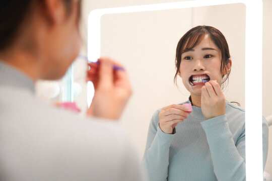 歯のホワイトニングをする女性