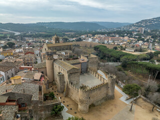 Fototapeta na wymiar Aerial view of Calonge town medieval castle with inner garrison courtyard surrounded by walls with crenallations and quare old tower, residential palace. Venue for music festival in Catalonia Spain