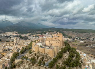 Fototapeta na wymiar Aerial view of Caravaca de la Cruz castle and medieval town in Southern Spain with stormy cloudy sky